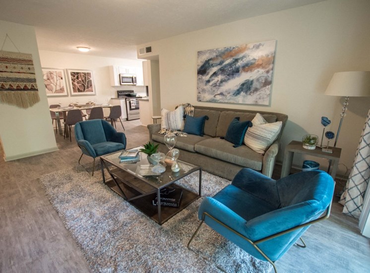 Entertain your family and friends in your spacious living room at Icon Avondale. Couches, table, chairs, light rug, light wood like flooring, open concept, spacious.